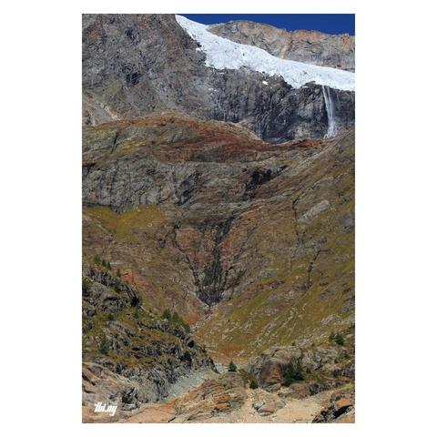 A more close up view of the same place with an even more abstract character, only show a small section of the reservoir zone at the bottom and focusing more on the higher up bedrock and glacier. A thin sliver of deep blue sky.