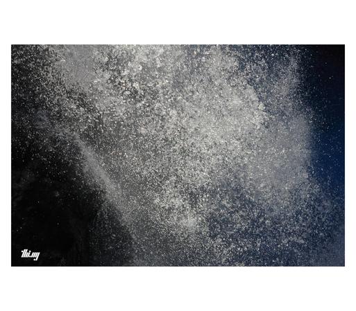 Close up view of water droplets of a large waterfall in freefall, shot against the bright morning light.