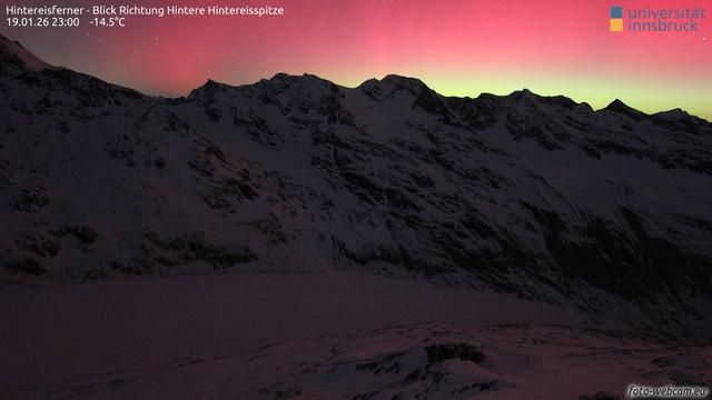 Webcam image from 23:00 CET showing a section of the Hintereisferner glacier illuminated by an red/pink aurora.