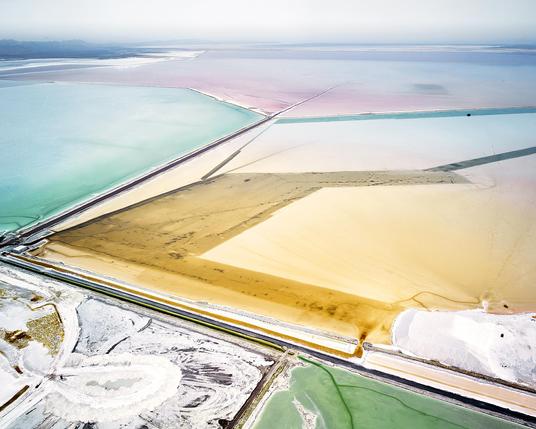 Photo credit: David Burdeny

Abstract aerial photo of large salt plains/basins in shades of white, yellow, cyan, green, pink, purple. A mountain range in the far distance.