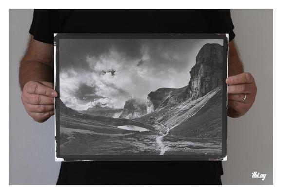 Photo of a person holding a 15x11" handmade kallitype print of a moody mountain landscape