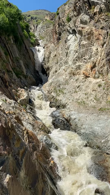 Edit of short phone videos showing different stages of glacial outflow. First segment: a creek (Platteibach) with heavy flow in a very steep narrow rocky canyon. Second segment: Combined intense outflow (Rofenache) of milky beige water in a larger rocky canyon, viewed from a bridge. Last segment: The confluence of Rofenache and Niedertalbach
