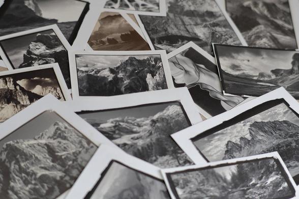 A dozen or so handmade kallitype prints of different sizes and tones, scattered on my sorting table for review. The prints mostly depict mountain landscapes in the Alps.
